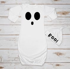 a white baby bodysuit with black eyes on it