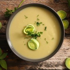 an overhead view of a bowl of soup with artichokes on the side