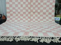 a pink and white checkered blanket sitting on top of a black table next to a potted plant