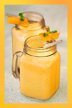 two mason jars filled with orange juice and garnished with mint