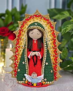 a crocheted statue of a virgin mary holding a baby jesus