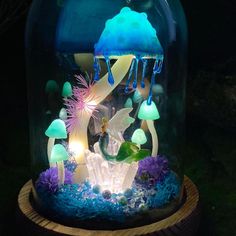 a glass dome filled with lots of different types of lights and decorations on top of a table