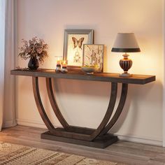 a console table with candles and pictures on it