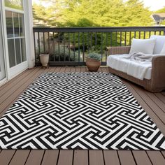 a black and white area rug on a deck with a couch in the background,