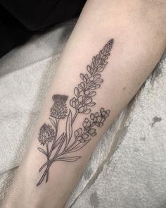 a black and white flower tattoo on the right arm, with small flowers in it