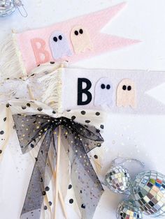 some type of decoration on a table with balls and streamers in the shape of ghostes