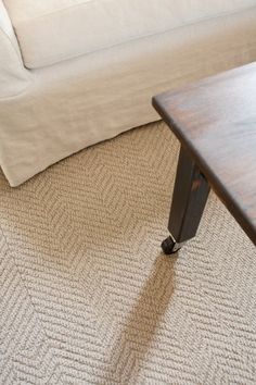 a coffee table sitting on top of a carpeted floor next to a white couch