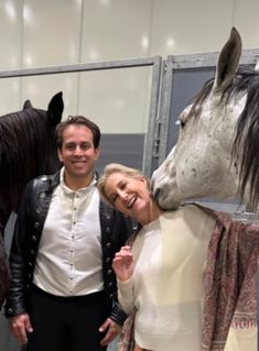 a man and woman standing next to a horse statue