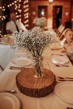 there is a vase with baby's breath in it on top of the table