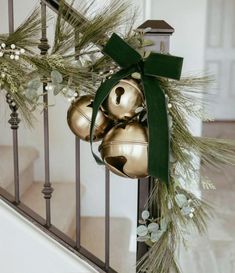 christmas decorations on the banister with bells and greenery