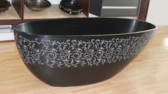 a large black bowl sitting on top of a wooden floor