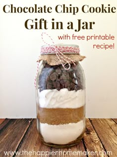 a jar filled with cookies and marshmallows on top of a wooden table