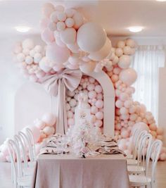 the table is set with white chairs and balloons