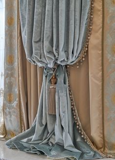 a curtain with tassels hanging from it's side in front of a window