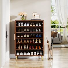 a wooden shoe rack filled with lots of pairs of shoes next to a door way