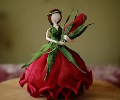 a red and green figurine sitting on top of a wooden table