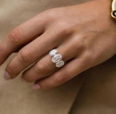 a close up of a person's hand wearing a ring with two stones on it