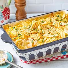 a casserole dish filled with pasta and cheese on a table next to other dishes