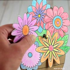 someone is drawing flowers on a piece of paper