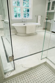 a bathroom with a claw foot tub and glass shower door