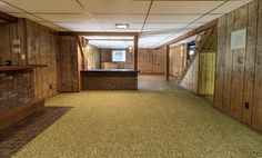 an empty room with wood paneling and tile floors