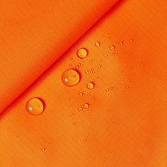 an orange fabric with water drops on it