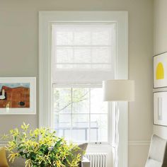 a living room filled with furniture next to a window covered in white shades and yellow flowers