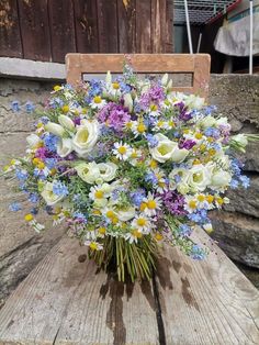 a bouquet of flowers sitting on top of a wooden chair