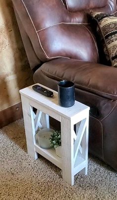 a brown leather couch sitting next to a white end table