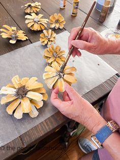 the woman is painting flowers on the table