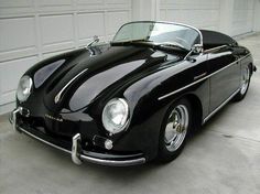 a black sports car parked in front of a garage