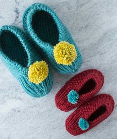 two crocheted baby shoes are laying next to each other on the floor,