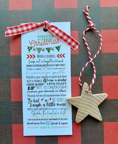 a wooden star ornament next to a christmas wish list on a red and white checkered tablecloth