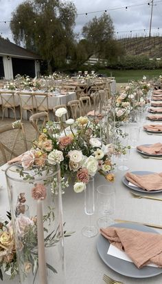 a table set up with flowers and place settings for an outdoor wedding reception at the farm