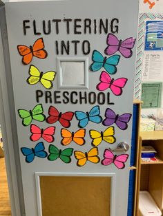 a classroom door decorated with butterflies and the words fluttering into preschool