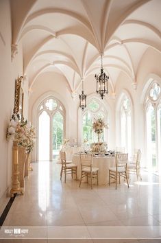 an elegant dining room with chandeliers and white table cloths set up for a formal function