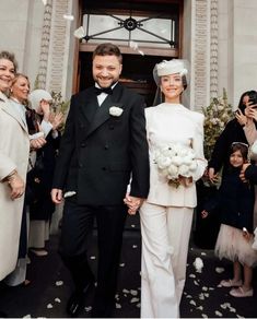 a bride and groom walking down the aisle with confetti falling all around them