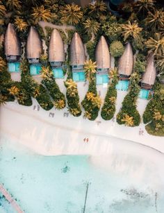 an aerial view of a beach resort surrounded by palm trees