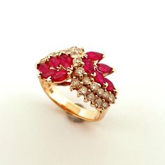 "A dazzling Ruby and Diamond Ring.  This glowing vivid red natural earth mined ruby and sparkly diamond ring is superb.  It is crafted in solid 14K yellow gold and weighs approximately 6.1 grams.  There are a full 2 carats of 20 point BRIGHT red marquise cut exceptional gem quality rubies set into this ring.  The rubies are arranged along the shoulders on each side and rise to join in the middle. A cascade of diamonds falls between the beautiful ruby laurel wreath clusters.  In total there is 1. Marquise Red Diamond Ring, Red Cluster Ring With Brilliant Cut For Anniversary, Red Cluster Ring With Brilliant Cut For Promise, Red Ruby Diamond Multi-stone Ring, Red Brilliant Cut Cluster Ring For Promise, Red Cluster Diamond Ring With Brilliant Cut, Red Ruby Multi-stone Ring With Diamonds, 14k Gold Red Cluster Ring With Brilliant Cut, Red Marquise 14k Gold Jewelry