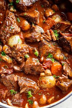 a pot filled with stew and potatoes on top of a table