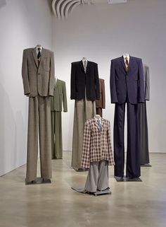 an assortment of suit and tie on display in a room