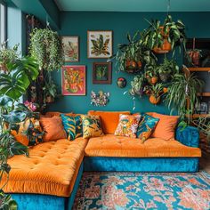 a living room filled with lots of plants and couches covered in colorful pillows on top of a rug