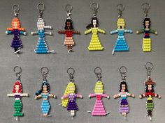 a group of beaded keychains that are shaped like women in different colors