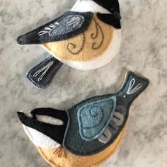 two small birds made out of felt sitting on a counter top next to each other