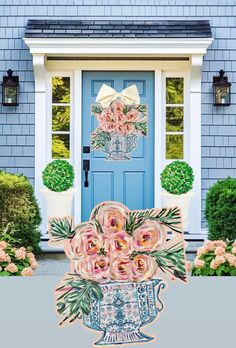 a blue front door with pink flowers on it and an ornate vase in front of it