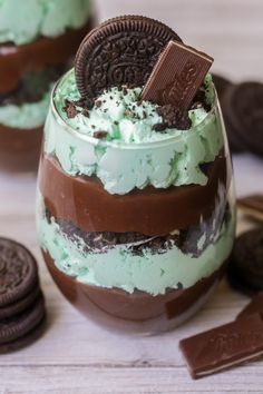 two glasses filled with ice cream and oreo cookies on top of a table next to an oreo cookie