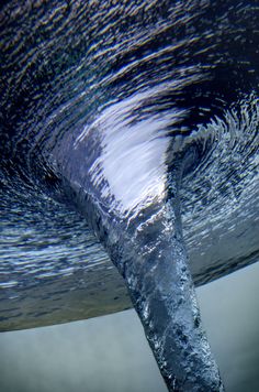 an image of water coming out of the bottom of a wave in blue and gray colors