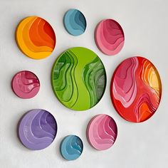 colorful plates are arranged on a white surface