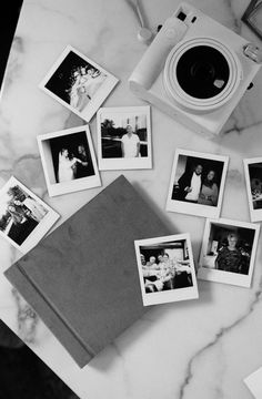 black and white photograph of family photos on marble counter top with polaroid camera next to them