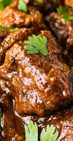 a close up view of some meat with parsley on top and green garnish